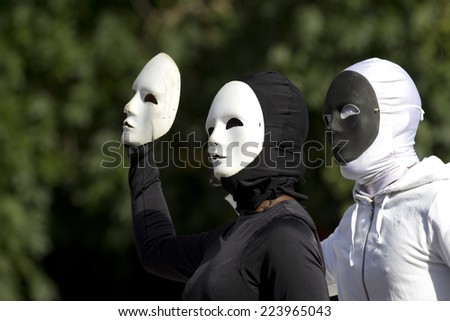 AURILLAC, FRANCE-AUGUST 25: two masked people play with their black and white masks as part of the Aurillac International Street Theater Festival, cie Bakhus 24,on august 25,2014, in Aurillac,France.