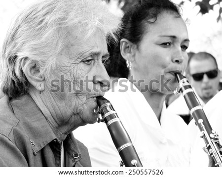 CIENFUEGOS, CUBA, DECEMBER 9: An old woman and an another musician play music in a square , on december 9, 2014 in Cienfuegos, Cuba.