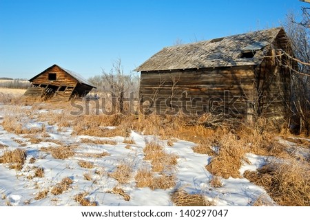 two old sheds in a snowy field