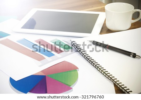Modern business workplace  on digital tablet, mobile banking on a smartphone and some charts and graphs on a desktop.