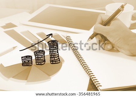 stack of coins graph with business charts on paper in background, online marketing ,income of business