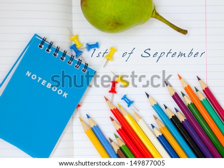 open school notebook for the first September with colored pencils, notebooks and stationery buttons