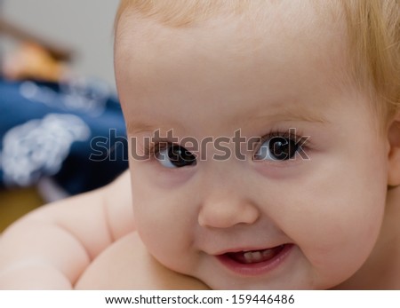 portrait of happy smiling baby with a sly look