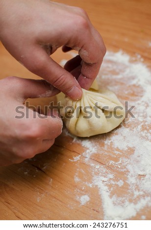 Men\'s hands make khinkali from dough closeup