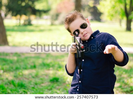 cool boy with a gun in the park