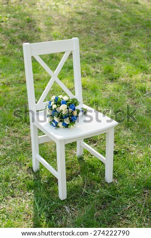 wedding bouquet on a wooden chair on a green lawn