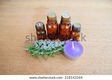 essential oils with small lavender candle and herbs