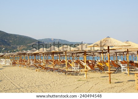 shiny summer beach with wooden umbrellas