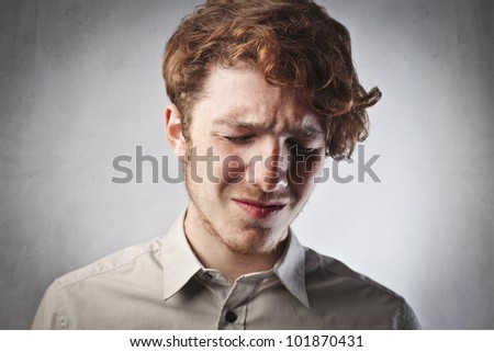 Sad young man with painful expression