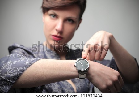 Beautiful woman showing the time on her wrist watch