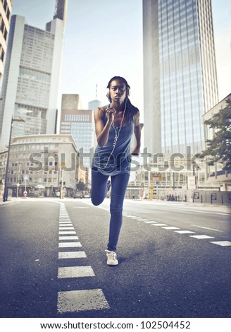 Beautiful young african woman jogging on a city street