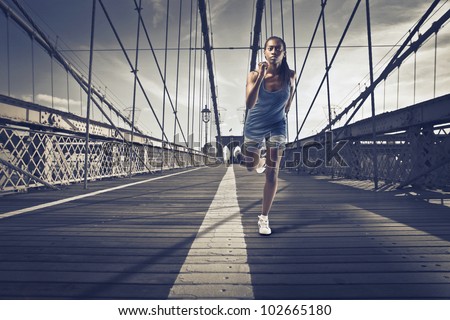 Young african woman running on Brooklyn Bridge