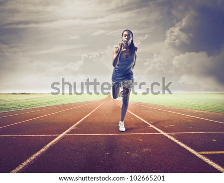 Young african woman running on a running track
