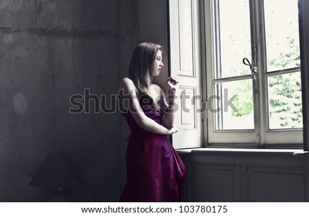 Beautiful elegant woman looking out of a window
