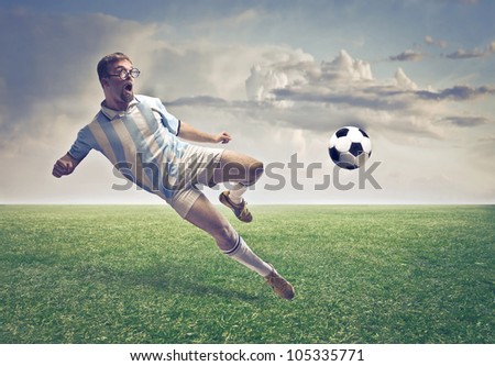 Soccer player shooting a ball on a football court