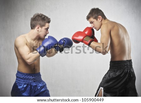 Two young boxers facing each other in a match Two young boxers facing each other in a match