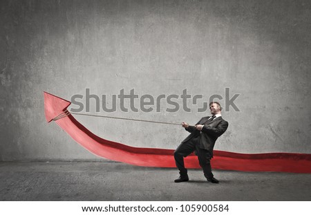 Businessman trying to lift a red arrow by pulling it with the help of a rope