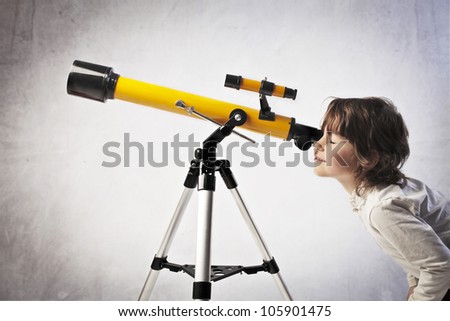Little girl using a telescope
