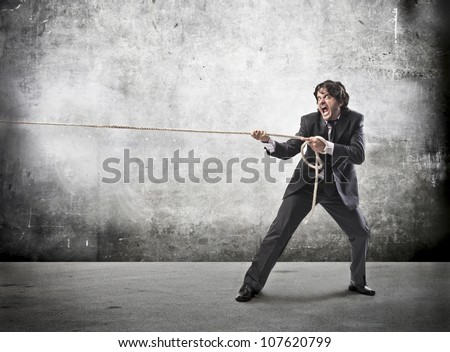Angry businessman pulling a rope