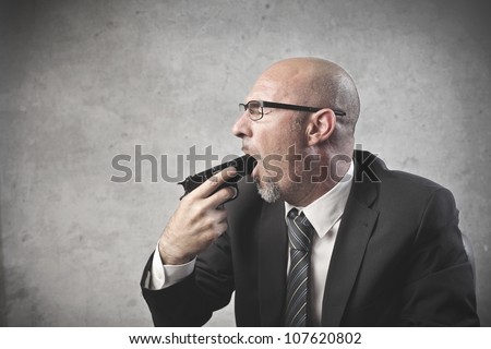 Businessman pointing a gun in his mouth