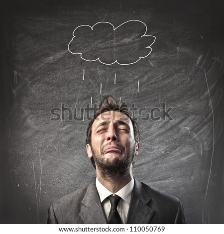 Sad young businessman with raincloud over his head Sad young businessman with raincloud over his head
