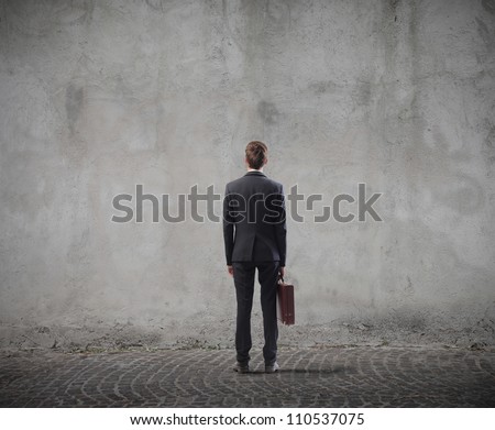 Rear view of a businessman standing in front of a wall