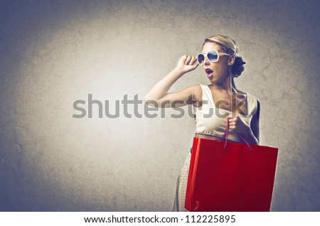 Girl with sunglasses bringing a red bag
