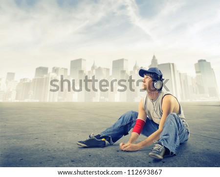 Street boy listening to the music on a ground near New York