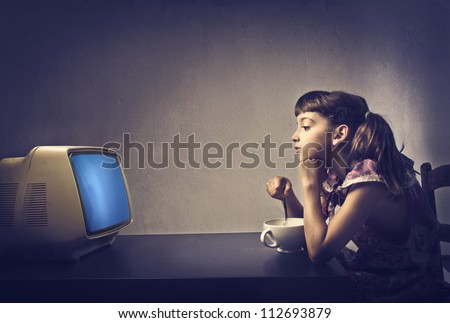 Child watching TV during the breakfast