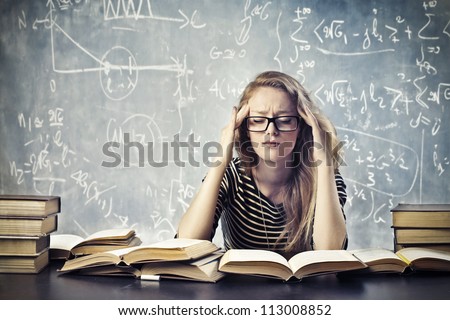 Beautiful blonde girl stressed by the study - stock photo