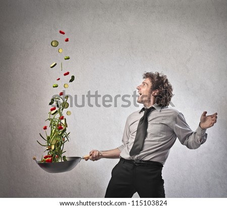 Businessman cooking vegetables with a pan