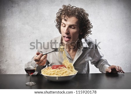 Man eating spaghetti and drinking wine