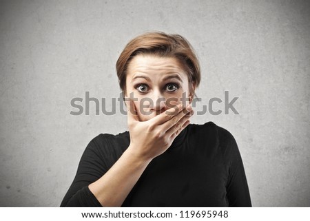Astonished woman covering her mouth with her right hand