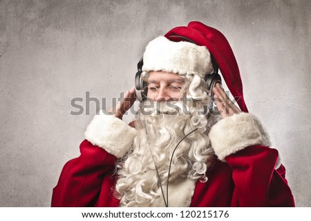 Santa Claus listening to the music with a pair of headphones Santa Claus listening to the music with a pair of headphones