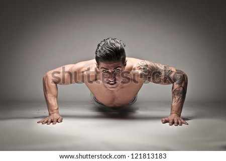 Tattooed man doing push ups