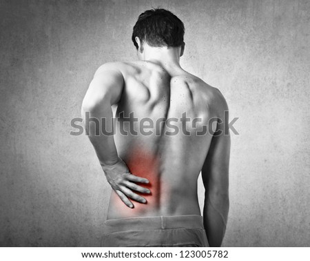 Shirtless Man Touching His Back For The Pain