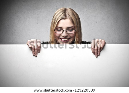 Smiling blonde girl looking down at a cardboard