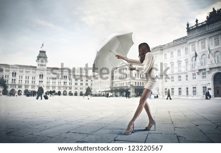 Young woman in white opening a white umbrella