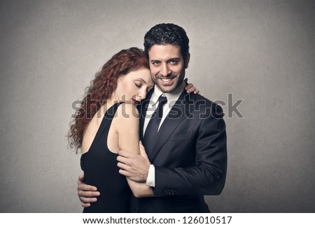 Elegant man embracing an elegant redhead woman