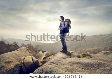 young man with backpack hiking in the mountains