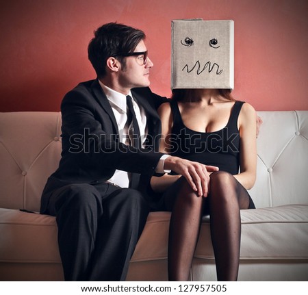http://image.shutterstock.com/display_pic_with_logo/160669/127957505/stock-photo-man-embraces-beautiful-woman-with-a-box-on-her-head-sitting-on-the-couch-127957505.jpg