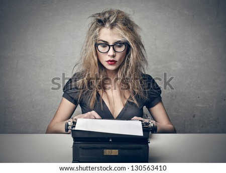 beautiful woman writes with a typewriter