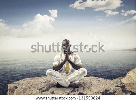 black man meditating with legs crossed
