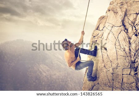 brave young man climbs a mountain