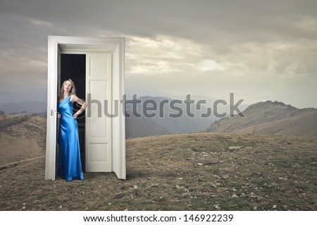 beautiful woman in evening dress opens a magic door