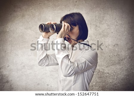 surprised young woman looking through binoculars