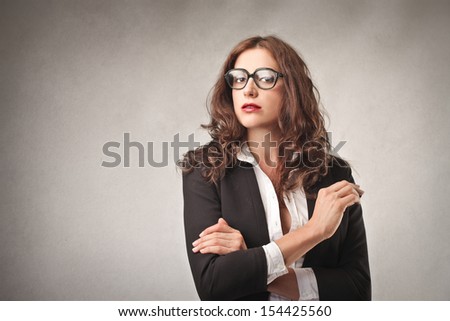 portrait of beautiful career woman with big glasses on gray background
