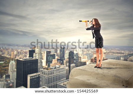 career woman looking with binoculars over the city