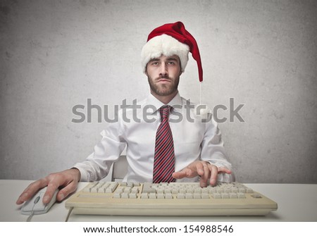 Businessman With Santa Hat Working On The Computer