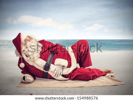 Santa Claus relaxes lying on the beach